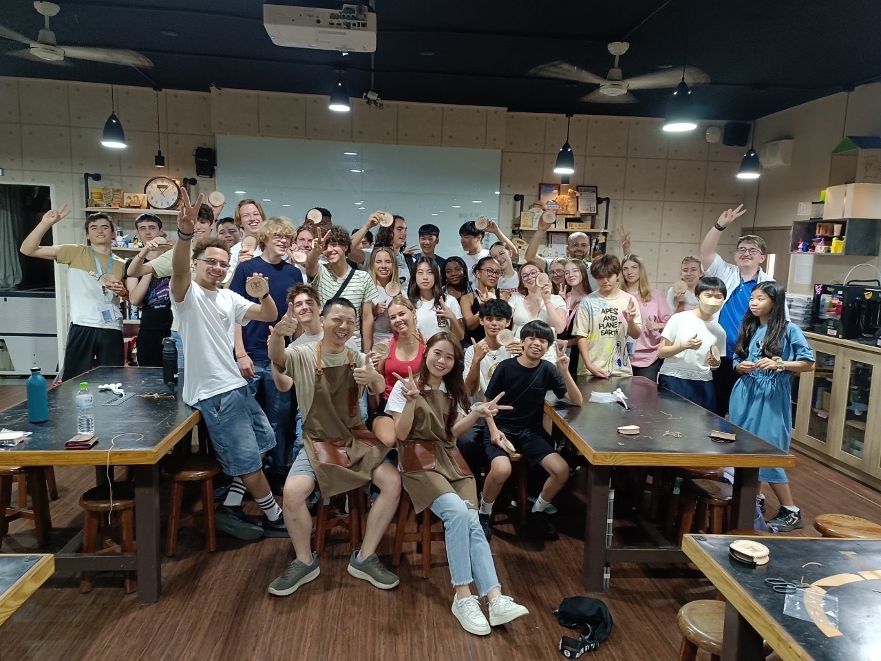 A group photo after a corporate class, students holding their finished work