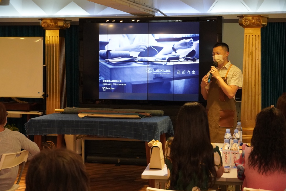 An instructor explaining leather at a corporate event while attendees look on