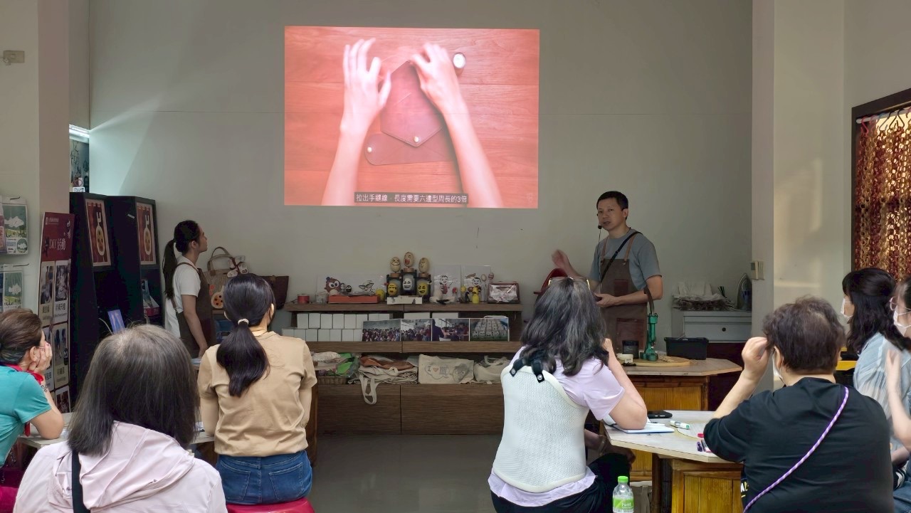 An instructor unrolling a hide to explain how to choose the right part of the leather