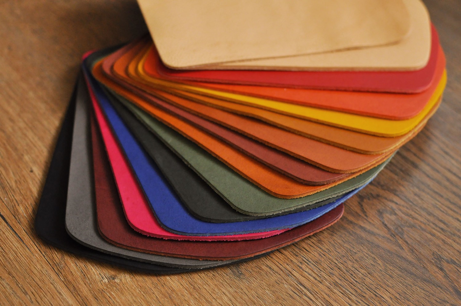 A fan of leather color swatches — red, orange, yellow, green, blue and purple vegetable-tanned samples