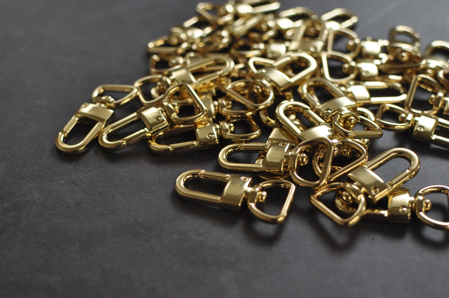 A gold lobster swivel clasp, a finding for straps and keychains