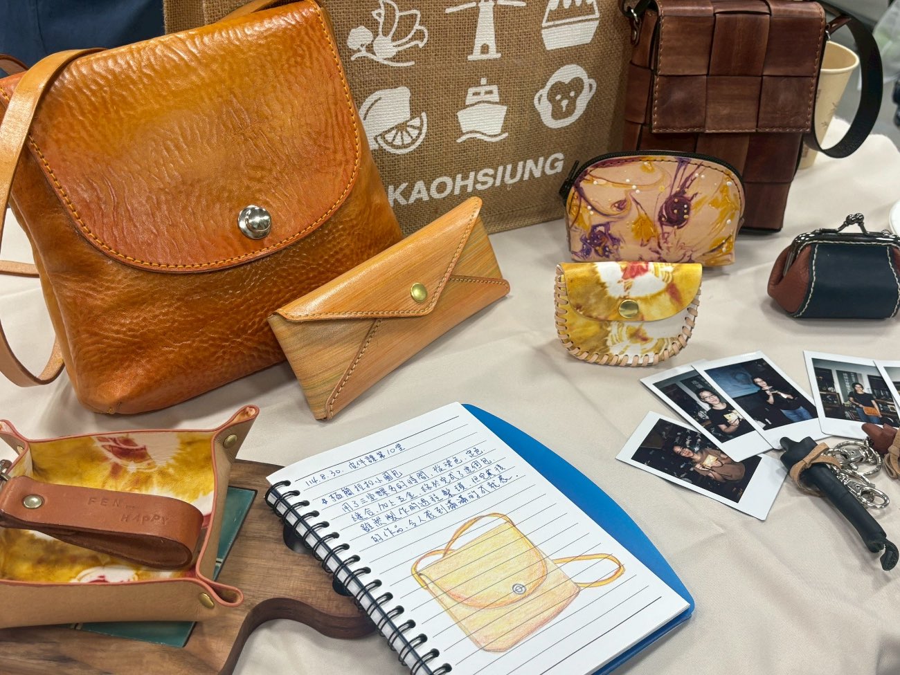 An array of student leather works laid out — bags, coin purses and small goods