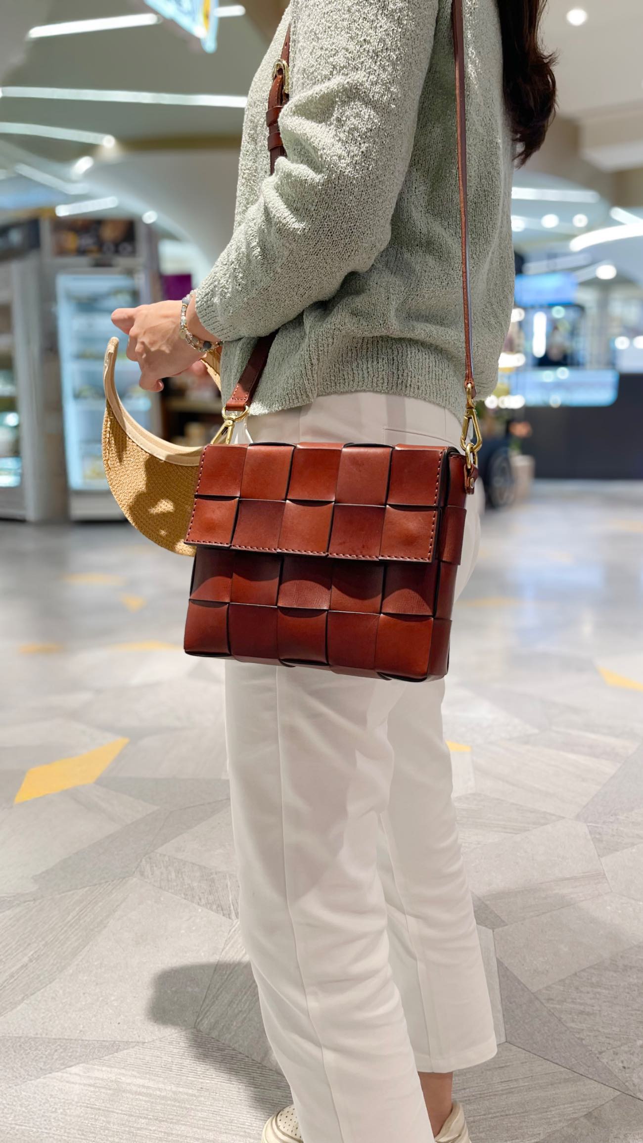 A colorful row of student-made leather bags in red, purple and orange-yellow